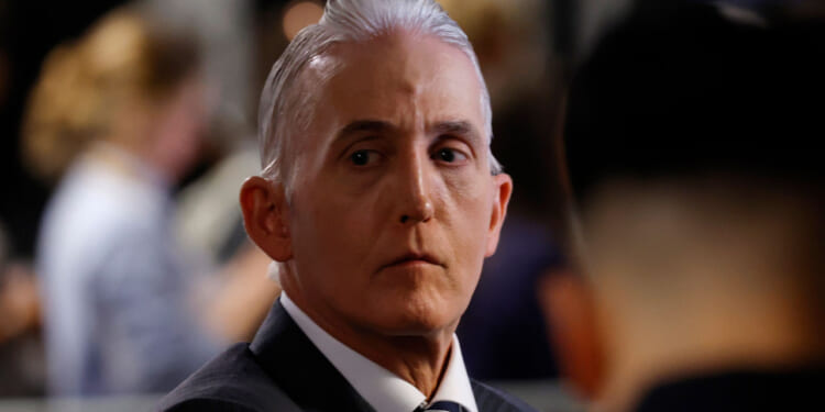 Trey Gowdy with slicked-back gray hair in a suit and tie looks to the side with a serious expression.