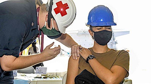 Hospital Corpsman 2nd Class Dillon Leggett, left, administers the COVID-19 vaccine to Intelligence Specialist 2nd Class Tairis Jacofernandez aboard the USS Hershel 'Woody' Williams in Rijeka, Croatia, March 30, 2021. (U.S. Navy photo by Mass Communication Specialist 2nd Class Eric Coffer)