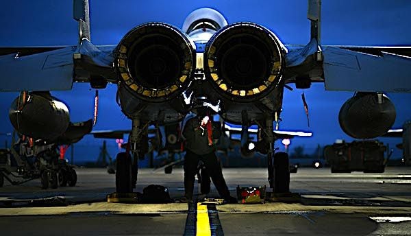 Air Force Staff Sgt. Brandon Thomas-Volkov inspects the underside of an F-15E Strike Eagle at Royal Air Force Lakenheath, England, Jan. 5, 2021. (U.S. Air Force photo by Senior Airman Madeline Herzog)