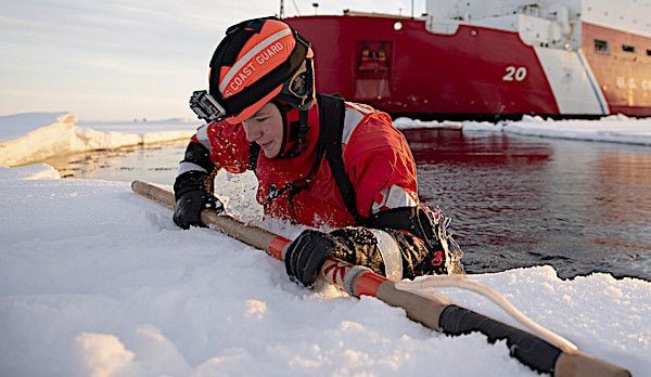 U.S. Coast Guard Petty Officer 3rd Class Shannon Eubanks pulls herself out from the Arctic Ocean during ice-rescue training Wednesday, Oct. 3, 2018, about 715 miles north of Barrow, Alaska. (U.S. Coast Guard photo by NyxoLyno Cangemi)
