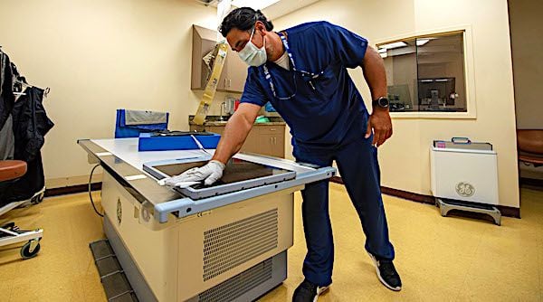 Kasey Kirchner, a radiology technician assigned to Naval Medical Center San Diego, sanitizes an X-ray machine in the hospital's Orthopedics Clinic, San Diego, Aug. 5, 2020. (U.S. Navy photo by Mass Communication Specialist 2nd Class Erwin Jacob V. Miciano)