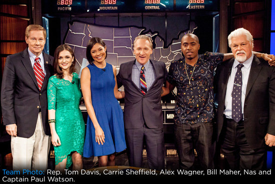 In an Age of Tribalism, Bill Maher Just Did Something Radical: He Admitted He Was Wrong 1 Six people stand together smiling in front of a U.S. time zone map on a TV studio set. They are dressed in business and semi-formal attire, with arms around each other, suggesting camaraderie and a group photo.