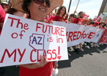 A person holds a sign that says The FUTURE of AZ is in MY CLASS! during a Red for Ed protest.