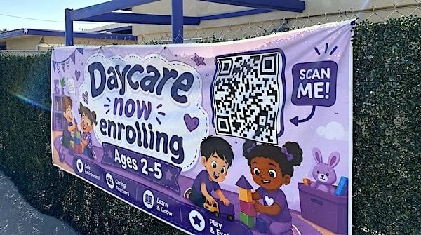 An enrollment banner hangs outside Willverines Childcare Center in Bakersfield, California, operated by the nonprofit William Law Foundation. Photo: Adam Herbets / The Center Square